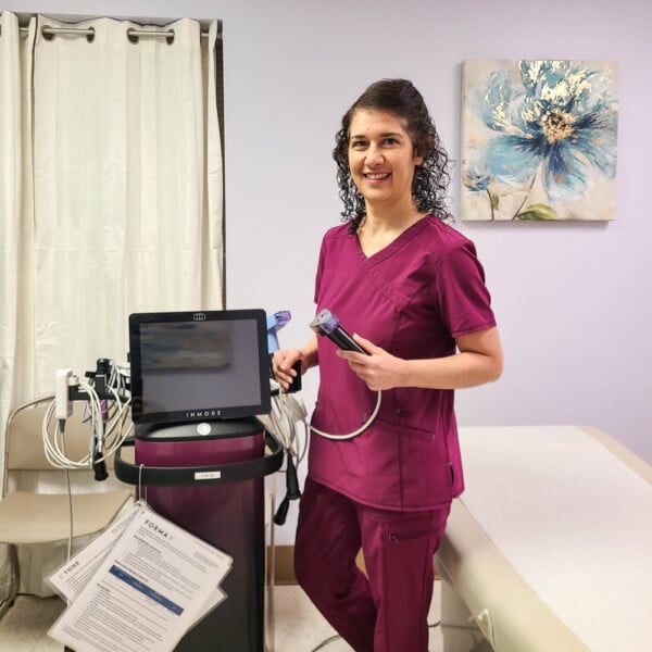 Dr. Sanam Campbell posing by the EmpowerRF machine