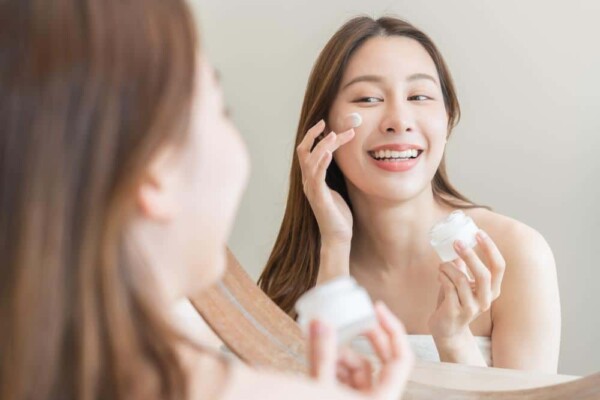 woman-applying-skin-cream-mirror-600×400 Young woman applying facial cream using a mirror
